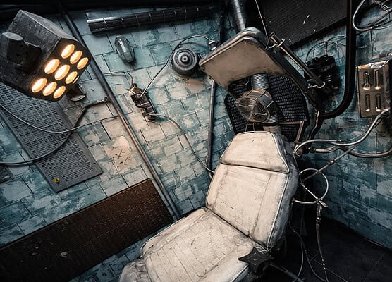Verlassener Raum mit Stuhl, Kamera und Technik für Escape Room Erlebnis.
